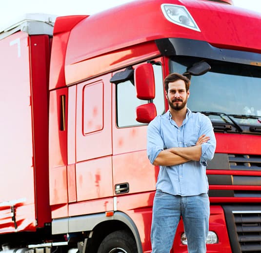 adult man with a red truck behind him